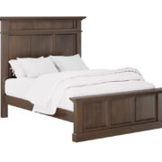 A neatly made bed in a wooden frame featuring a stylish headboard and footboard