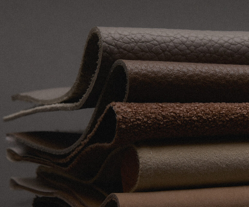 Stacked leather swatches in earthy tones showing grain and suede textures
