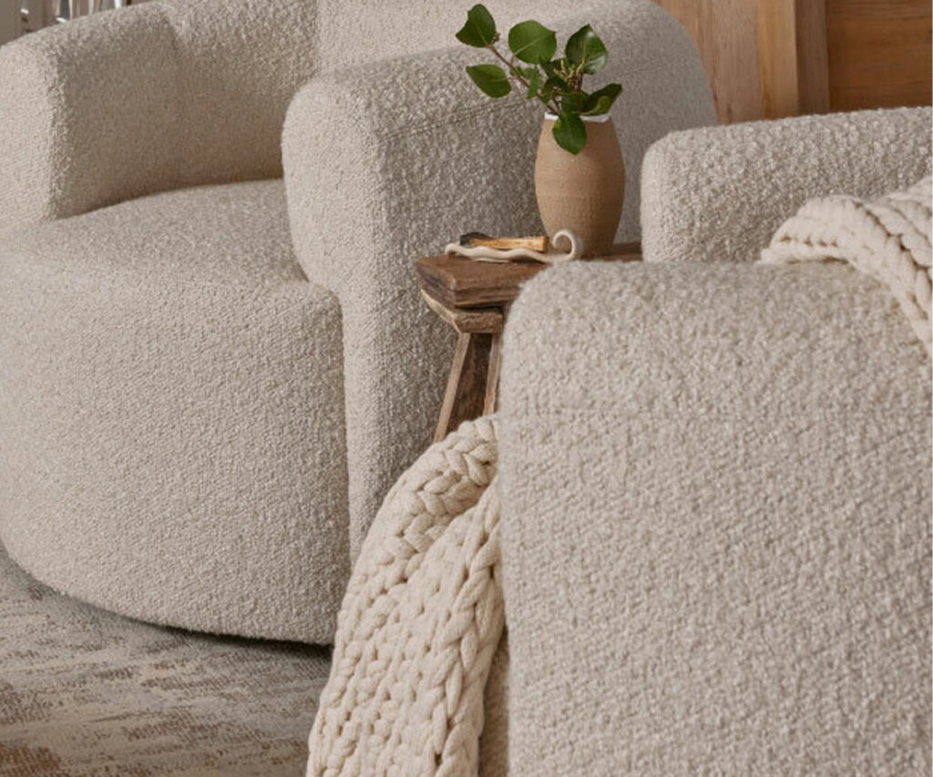 Curved cream bouclé chairs with chunky knit throw, pet and kid-friendly fabric