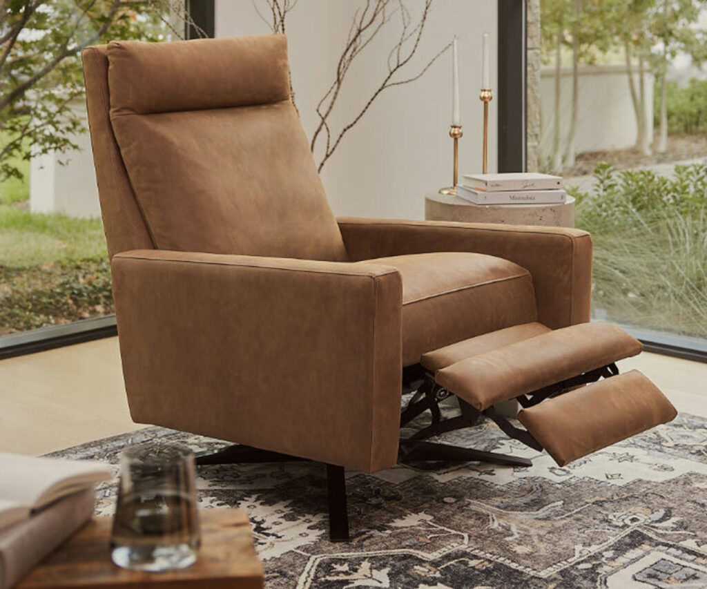 Tan leather recliner with extended footrest by bedroom window