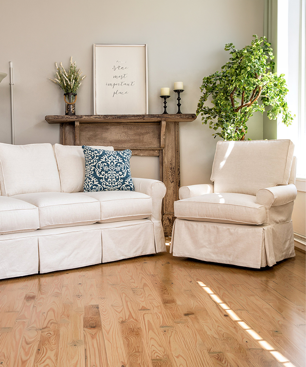 Four Seasons Furniture cream slipcovered sofa and armchair in a bright, rustic living room.